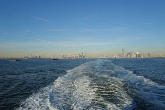 Stunning view of the New York City skyline from the water with clear blue skies, perfect for travel and tourism content.