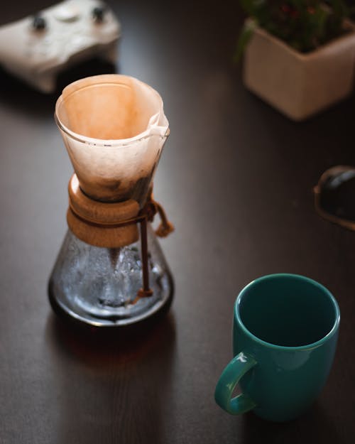Фотография заваренного кофе возле пустой кружки