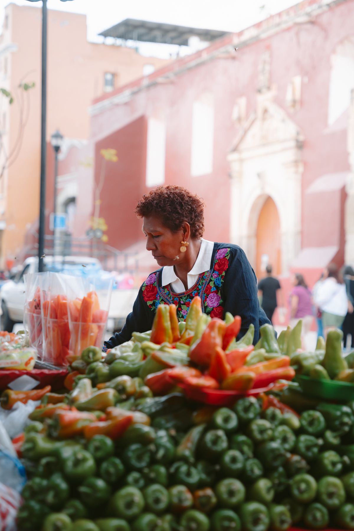 A Mexican market vendor arranges traditional vegetables in Oaxaca de Juárez market.