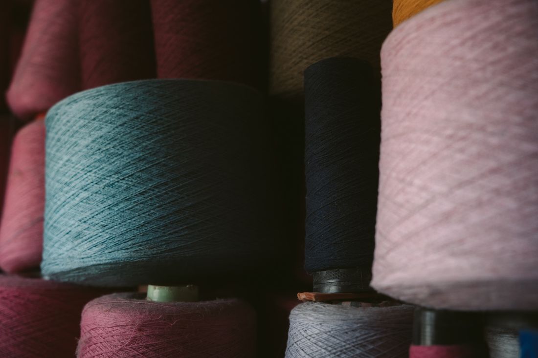 Stacked cones of coloured yarn in a textile warehouse