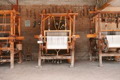 Three wooden looms in an artisan workshop in Oaxaca, Mexico, showcasing local craftsmanship.