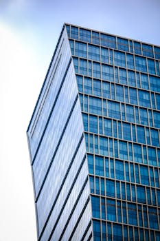 A modern glass skyscraper against the blue Shanghai sky, emphasizing architecture and urban development.