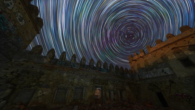 Captivating long exposure of star trails above historic stone ruins at night.