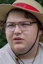 Young Man Wearing Straw Hat and Glasses Outdoors