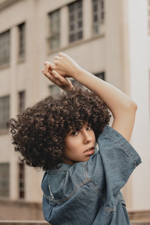Free Portrait of a stylish woman with curly hair posing outdoors in Santos, Brazil. Stock Photo