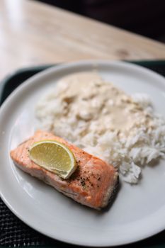 Savor a plate of salmon fillet with creamy rice and a hint of lime.