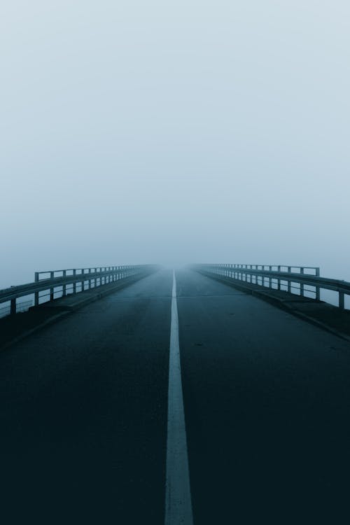 Empty Road Under Cloudy Sky