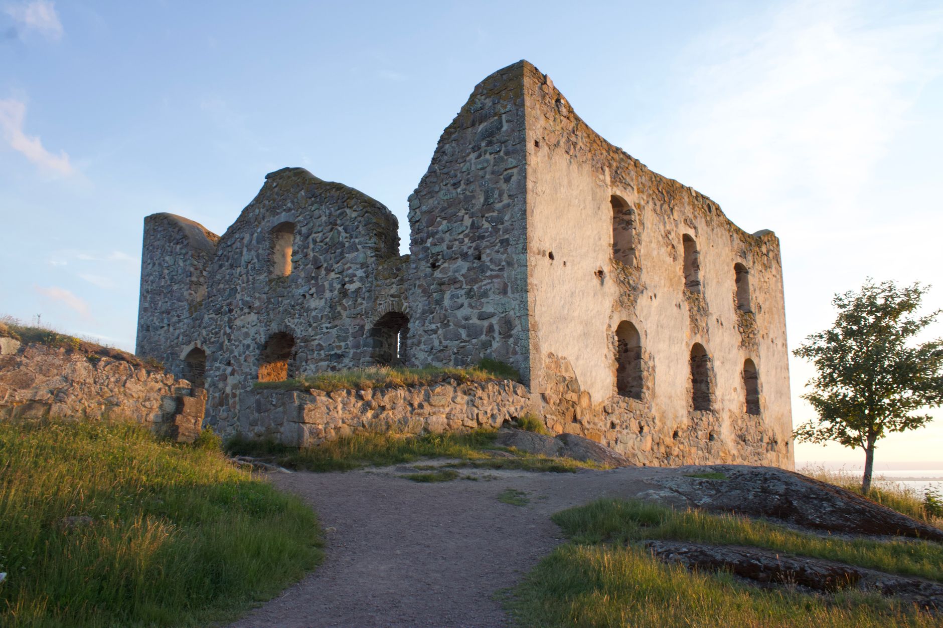 Explore the captivating medieval ruins of Brahehus Castle near Gränna, Sweden, bathed in golden sunset light.