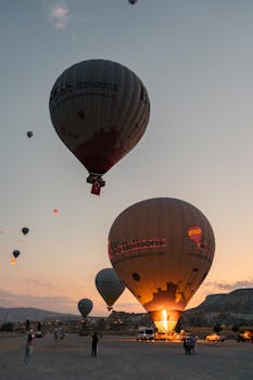 Hot air balloons ascending at sunrise over Cappadocia, Turkey, creating a mesmerizing landscape view.