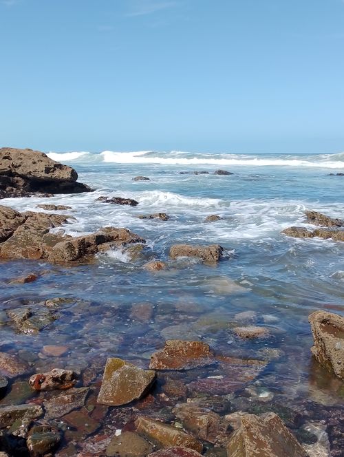 Free Explore the rocky shoreline of Casablanca with clear blue skies and vibrant sea waves. Stock Photo