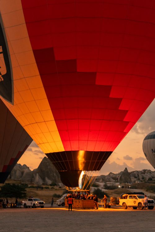Free Mesmerizing hot air balloons prepare for flight during a sunset in Cappadocia. Stock Photo