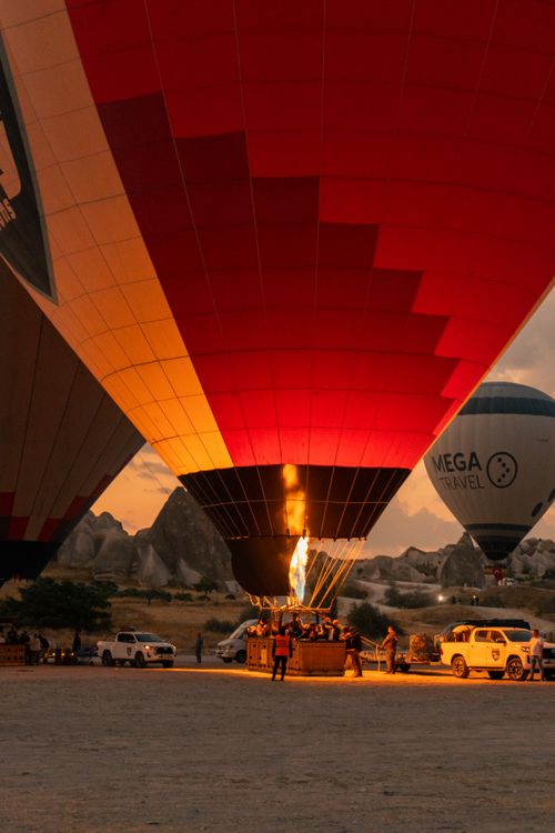 Free A vibrant hot air balloon being prepared for flight at sunset, offering a scenic view. Stock Photo