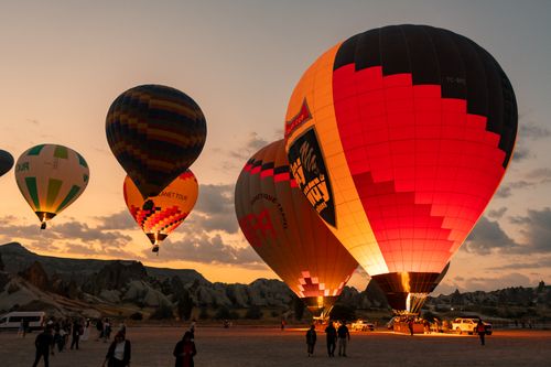 Free Vibrant hot air balloons light up the evening sky in Cappadocia, creating a stunning sunset silhouette. Stock Photo