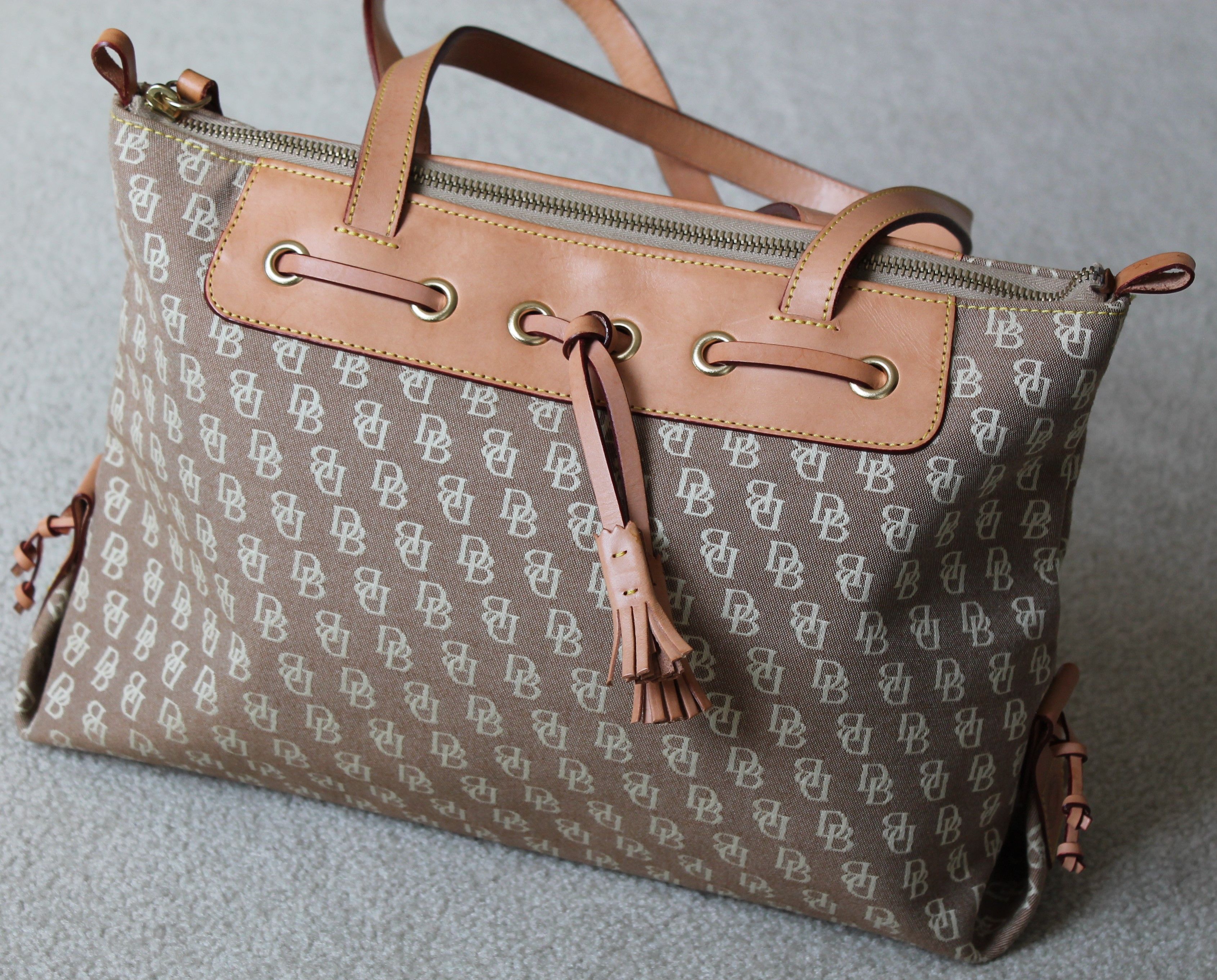 Stylish beige canvas tote bag with leather details, perfect for fashion enthusiasts.