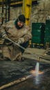 Welding Technician Using Blowtorch in Workshop