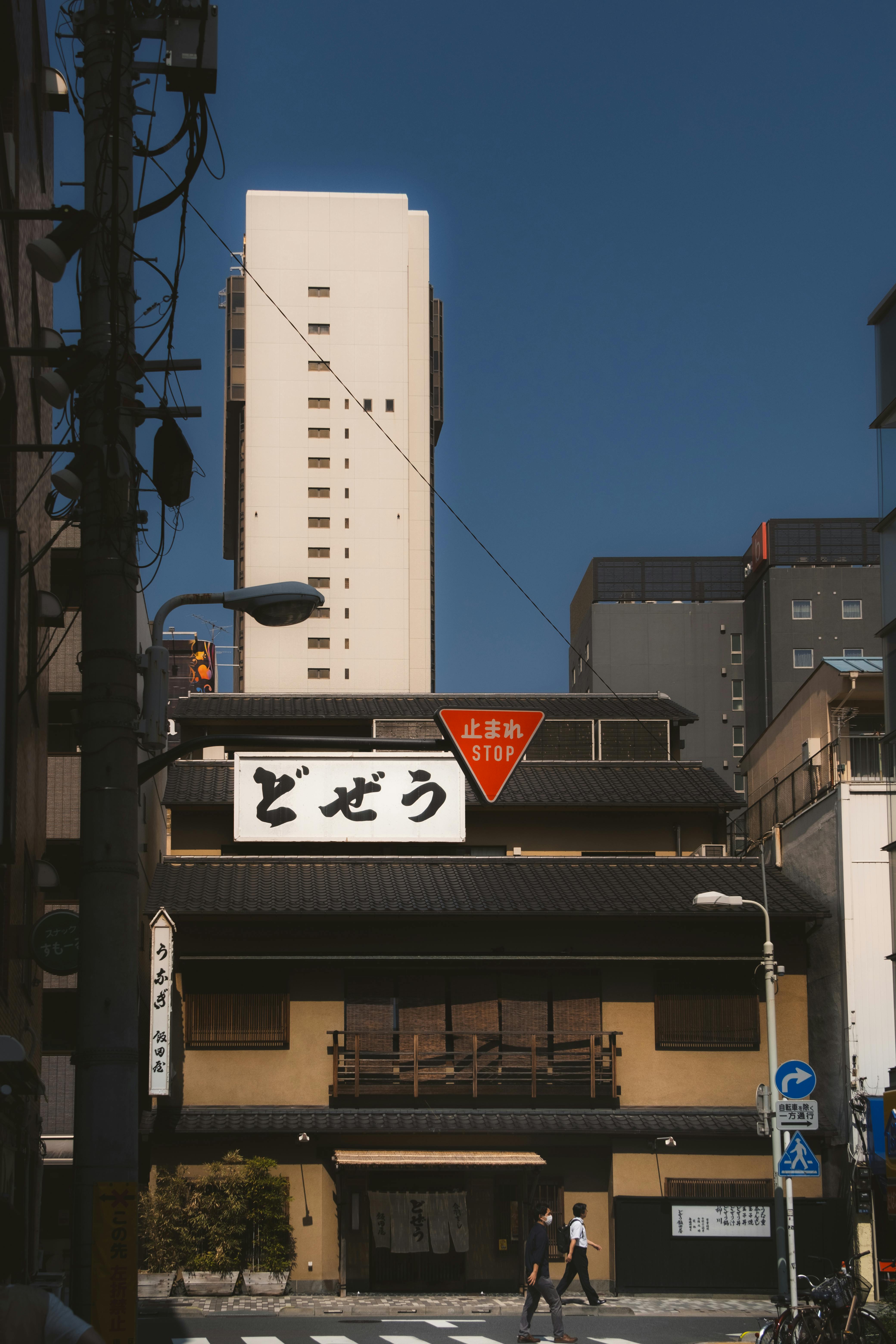 Urban street view in Japan featuring traditional architecture under a clear blue sky.