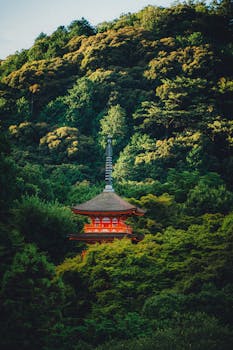A picturesque pagoda nestled in a vibrant green forest, bathed in warm sunlight.
