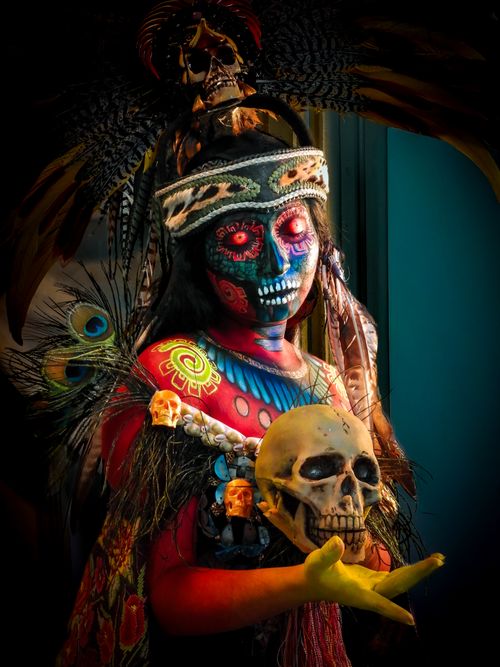 Free Colorful portrait of a woman in Day of the Dead attire holding a skull, showcasing cultural beauty. Stock Photo