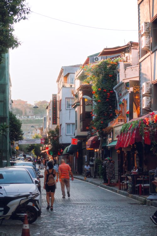 Free European street lined with colorful cafés and shops during the day. People walking and enjoying the architecture. Stock Photo