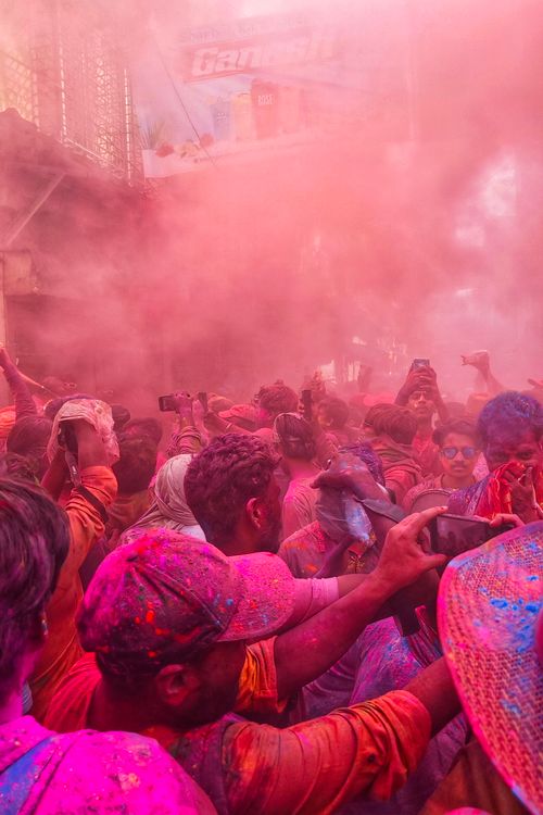 Free Vibrant street scene of people celebrating Holi with colorful powders in Kolkata, India. Stock Photo