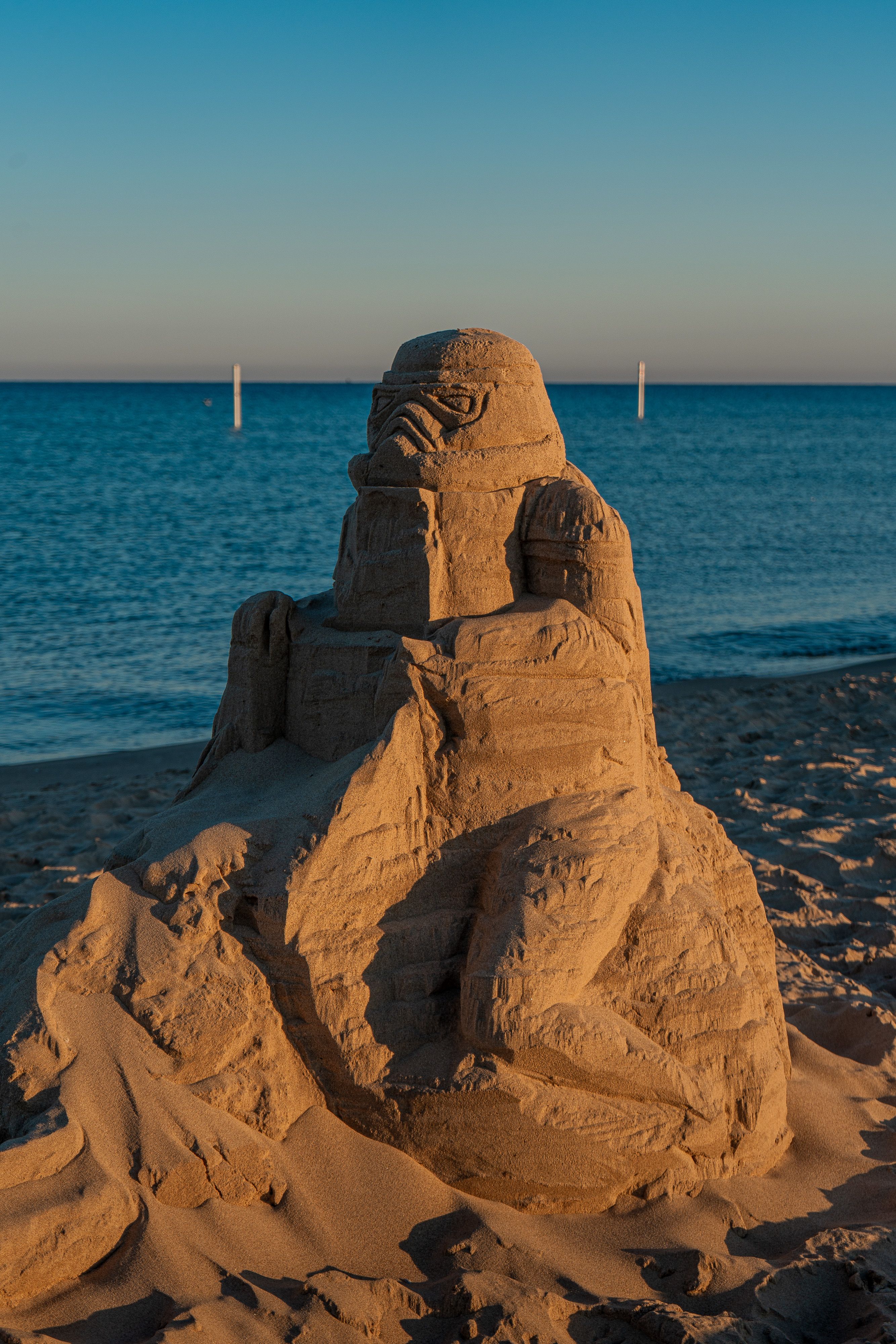 Detailed sand sculpture on a Holland, Michigan beach at sunset.