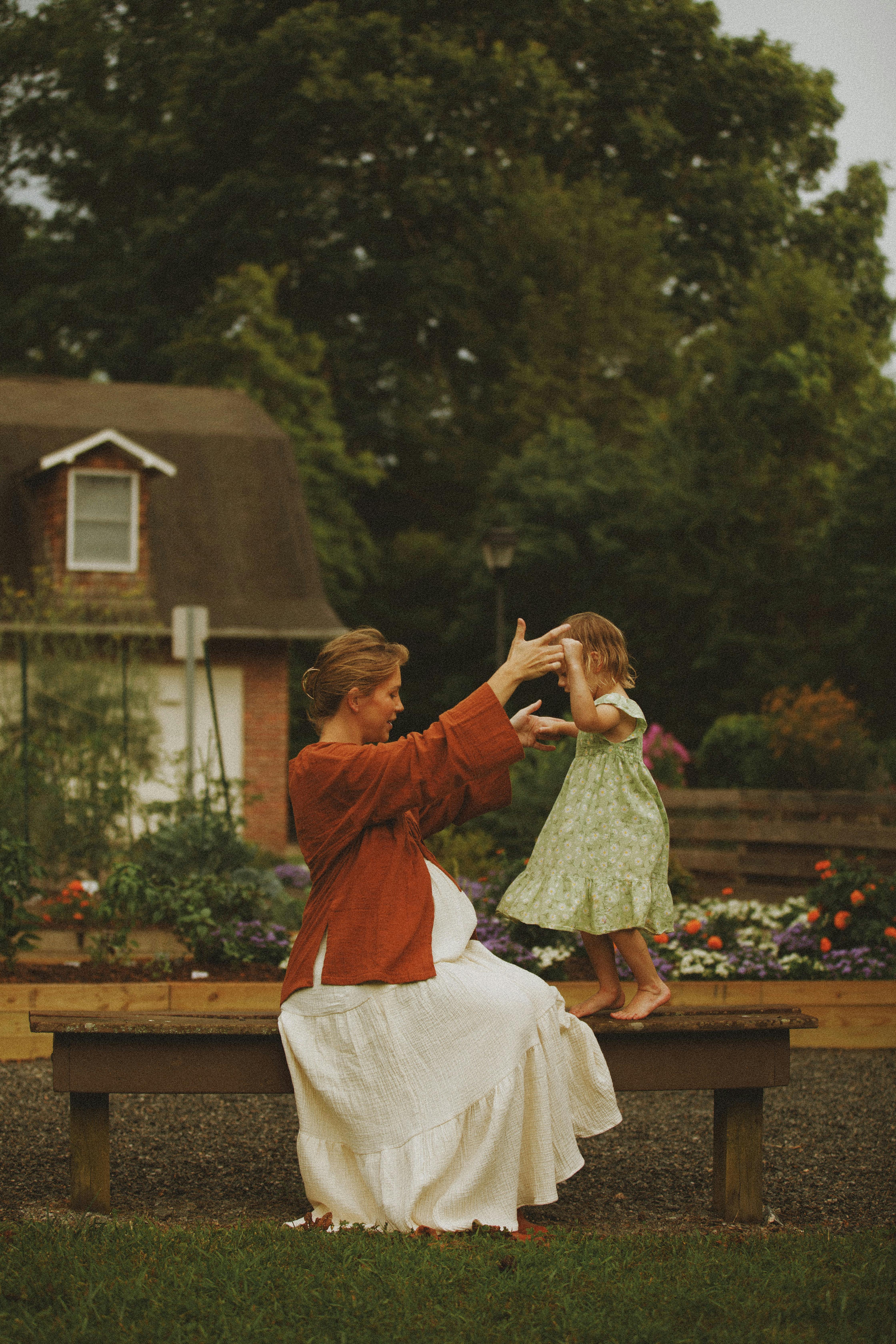 A joyful moment between a mother and daughter in a serene garden setting.