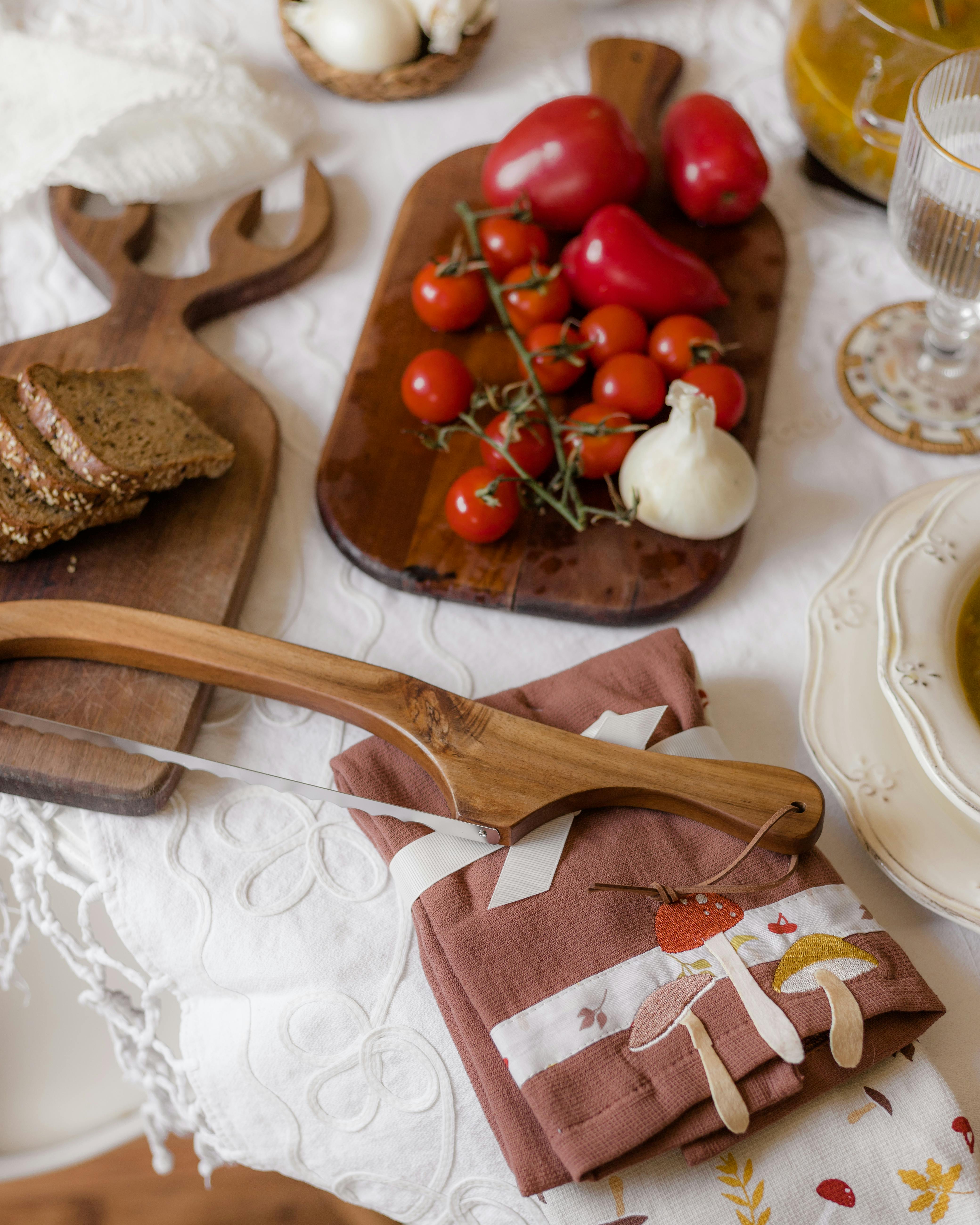 Beautifully arranged kitchen spread featuring fresh tomatoes, peppers, bread, and a unique bread cutter.