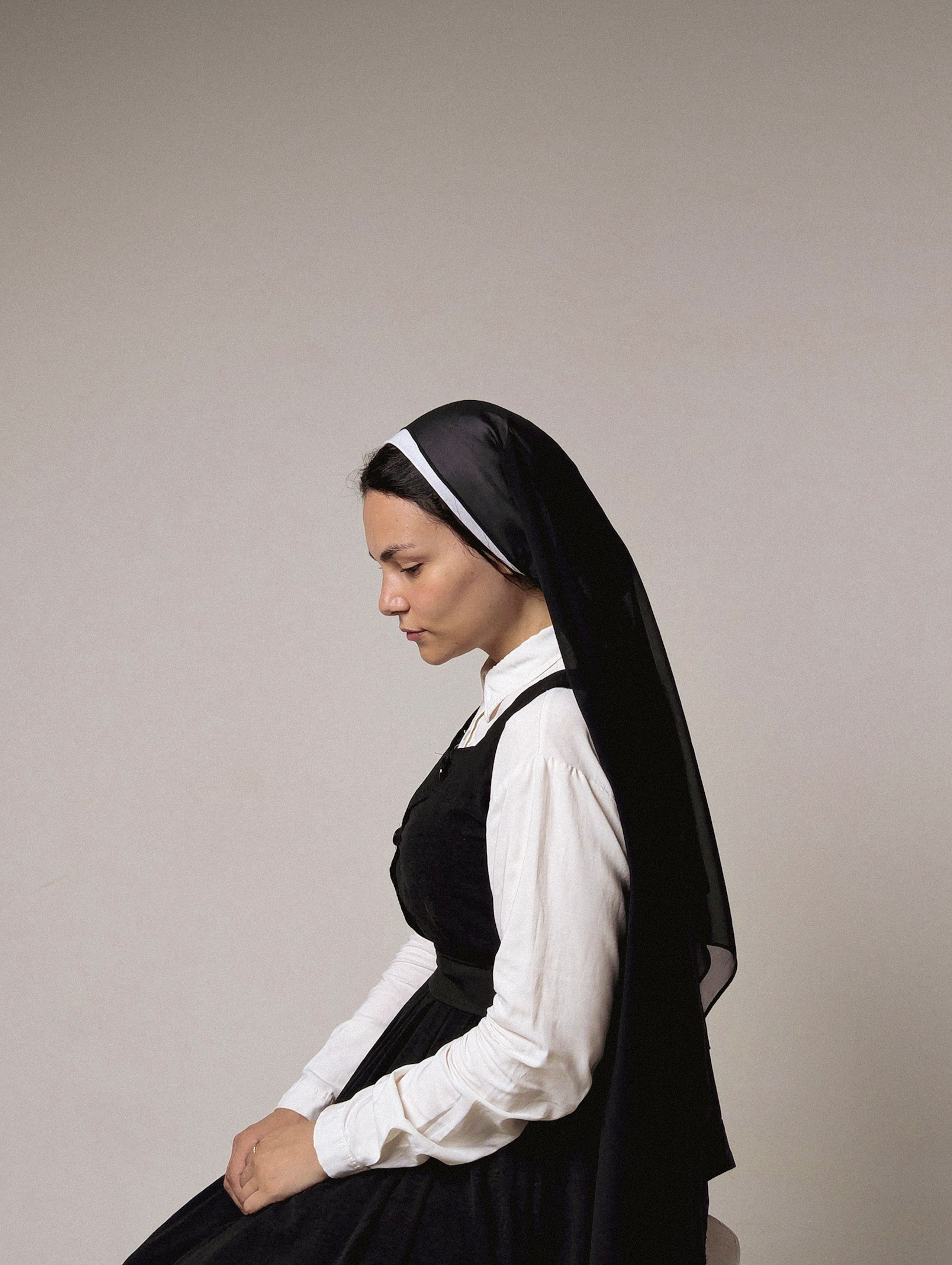 Profile Portrait of a Pensive Nun in Traditional Habit · Free Stock Photo