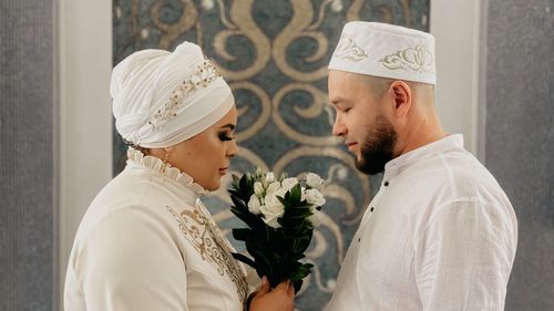 Free A couple in traditional attire sharing a loving moment indoors. Stock Photo