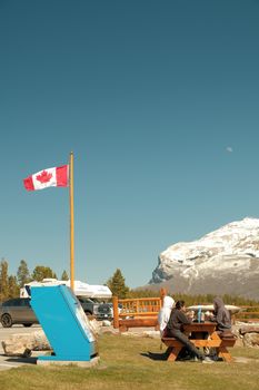 Friends enjoying a picnic with mountain views in Banff, Alberta, Canada.