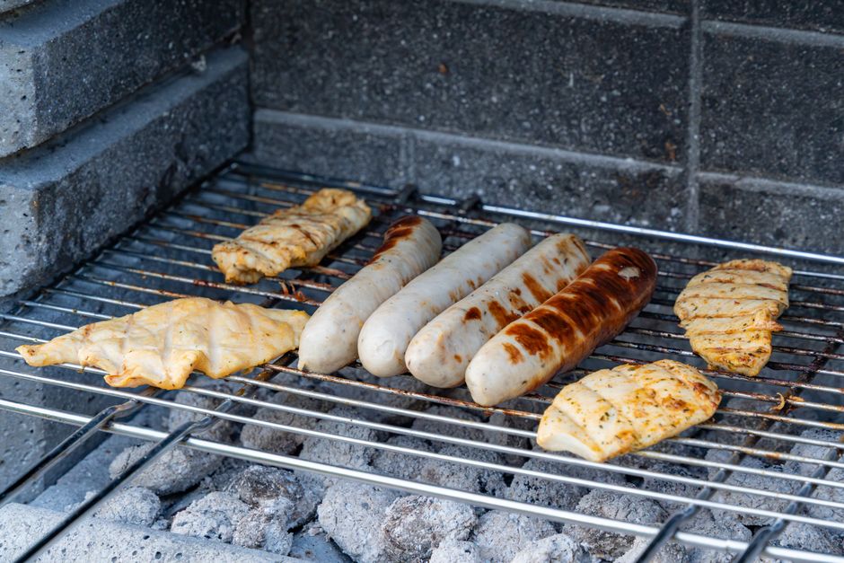Delicious grilled sausages and chicken on a barbecue grill. Perfect for summer cookouts.