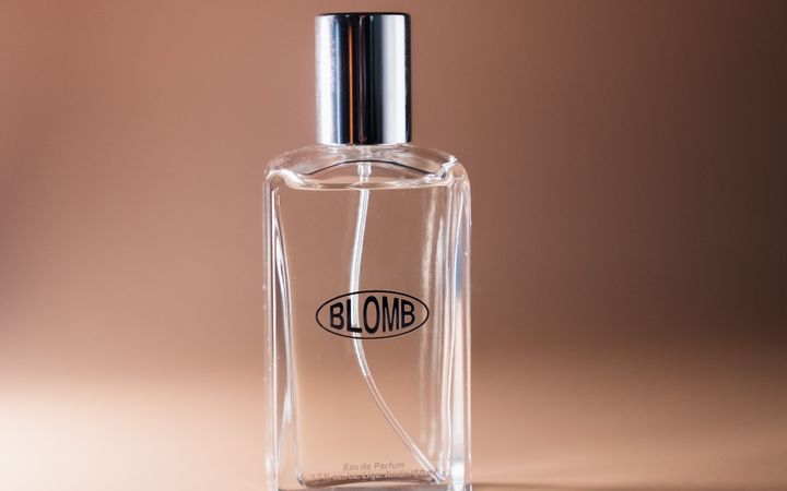 Transparent perfume bottle with elegant design on a warm-toned background, ideal for lifestyle imagery.