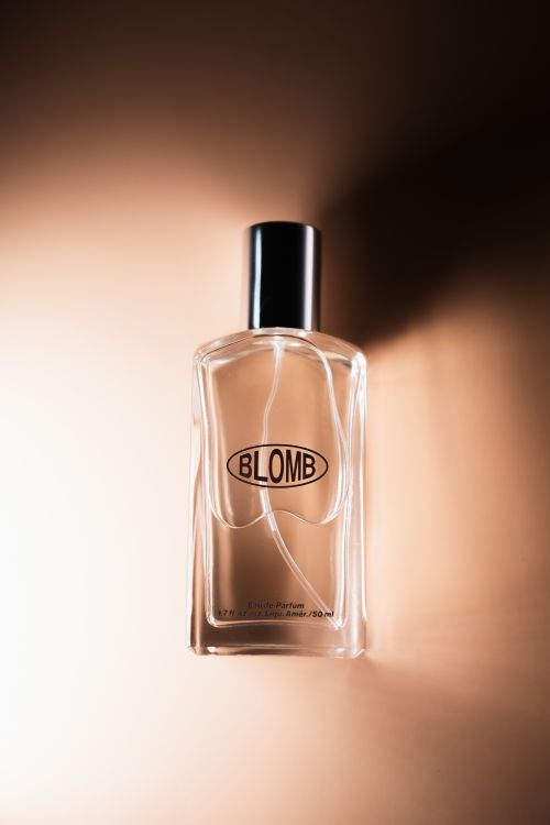 Free A sleek and elegant perfume bottle with a minimalist design on a warm-toned background. Stock Photo
