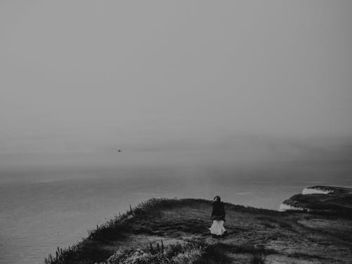 Grayscale Photography of Person on Cliff