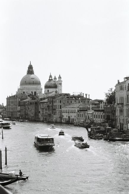 Scenic black and white photo of the Grand Canal in Venice featuring historic architecture and boats.