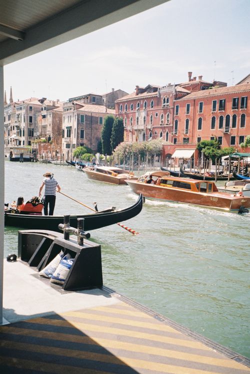 Free Gondola and boat on a colorful canal in Venice, Italy, with historic architecture. Stock Photo