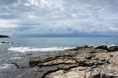 Free Captivating view of a rocky shoreline in Croatia under a dramatic cloudy sky. Stock Photo