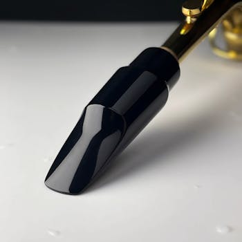 Close-up of a sleek saxophone mouthpiece with gold accents.