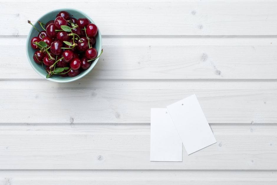 A bowl of ripe cherries on a wooden table, offering freshness and a hint of summer.