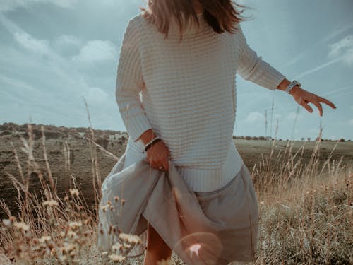 Standing Woman in White Sweater on Plant Field