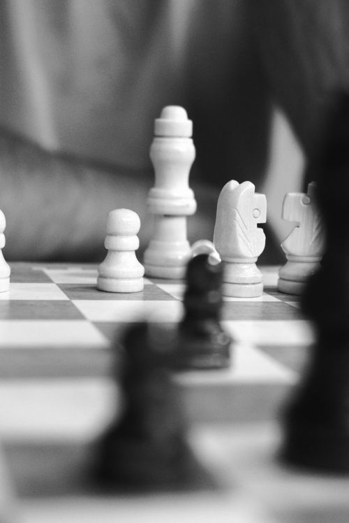 Free Black and white close-up of an intense chess game, highlighting pieces in play. Stock Photo