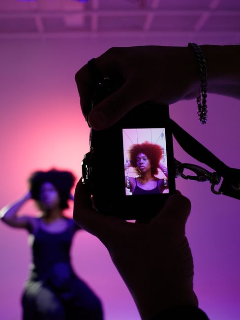 Photographer captures a model with vibrant lighting in a creative portrait session.