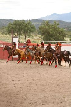 A group of traditional horse riders in San Juan Tizahuapan, México performing in an outdoor arena.