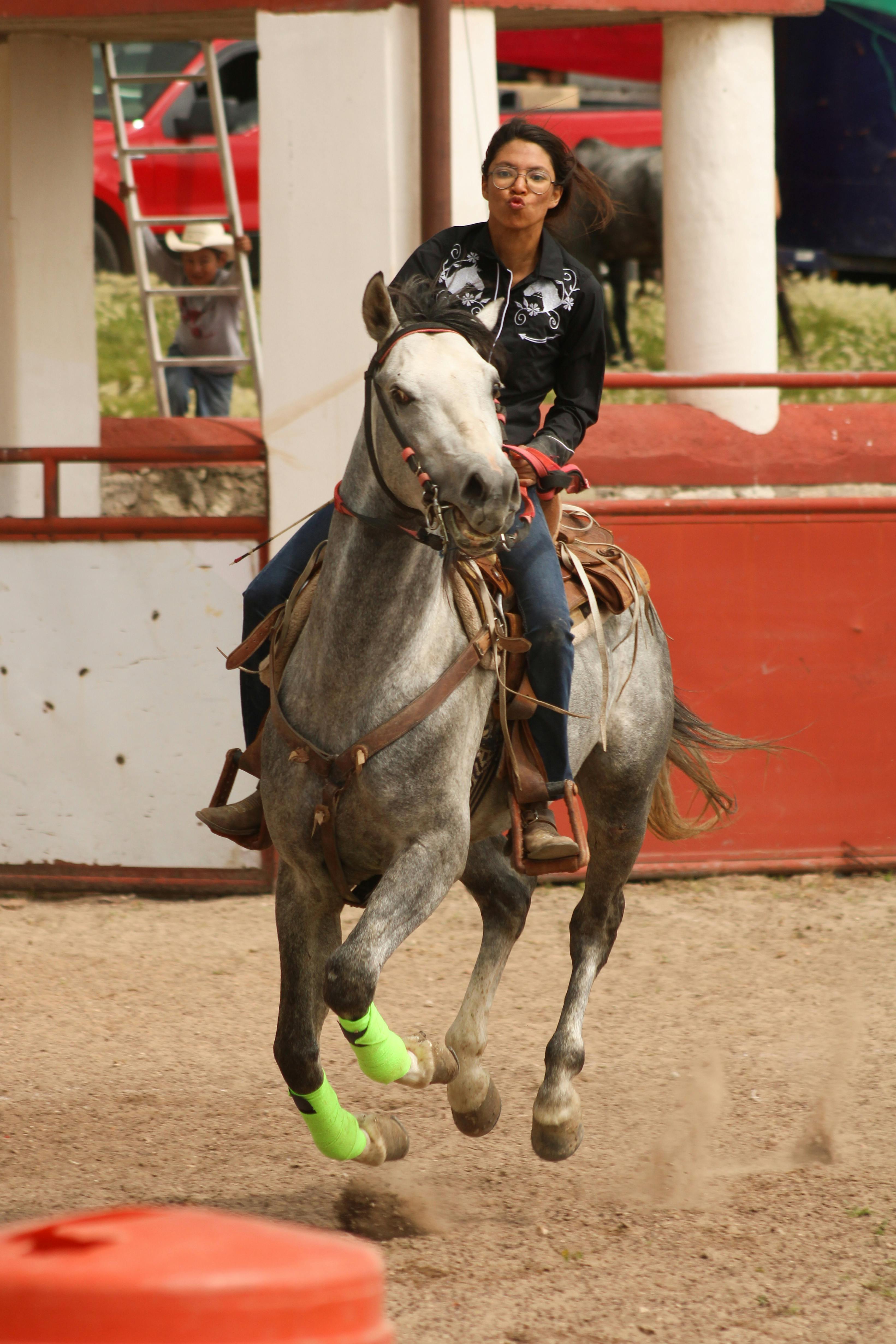 Adult woman showcasing traditional horse riding skills in San Juan Tizahuapan, México.