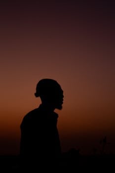 A man's silhouette against a vibrant sunset sky, showcasing serene twilight moments.