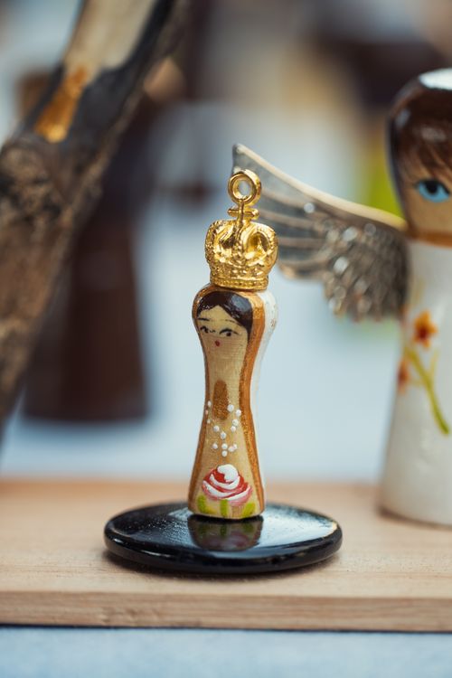 Free Close-up of a handcrafted wooden angel figurine with a golden crown and delicate painting details. Stock Photo