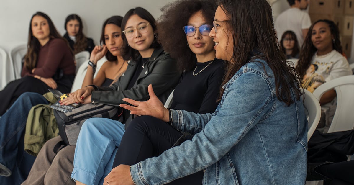 A diverse group of adults attentively sitting indoors during an engaging workshop session.