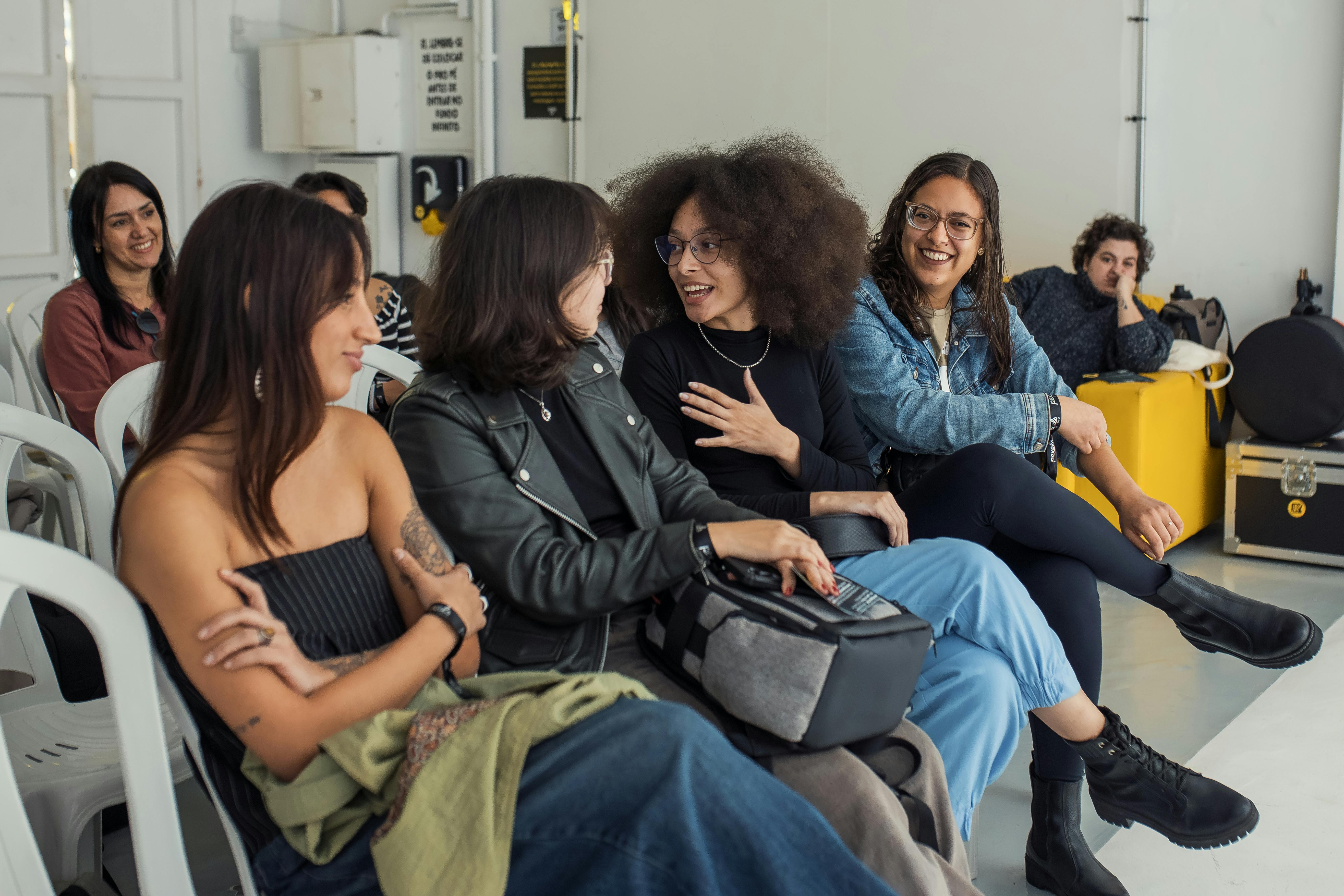 A group of young adults conversing and enjoying a casual indoor setting.