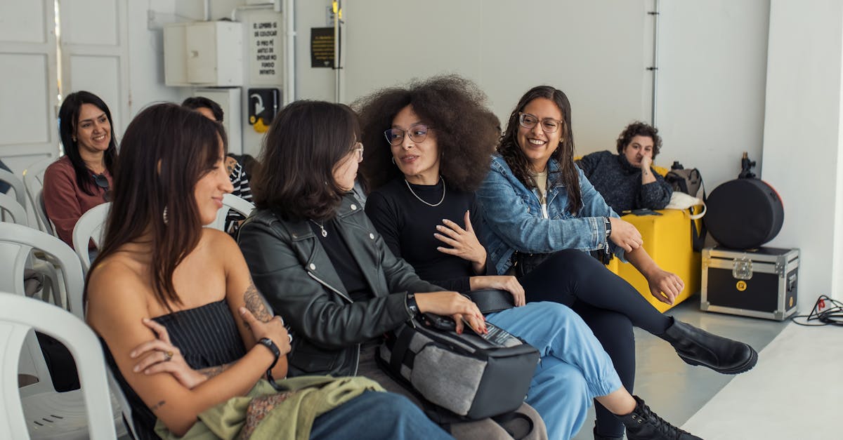 A diverse group of friends enjoying a lively conversation indoors, showcasing camaraderie and diverse fashion styles.