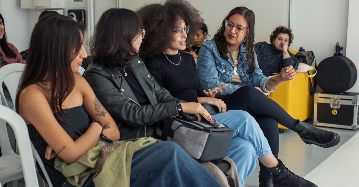 Group of young adults sitting and chatting at an indoor event, smiling and engaged.